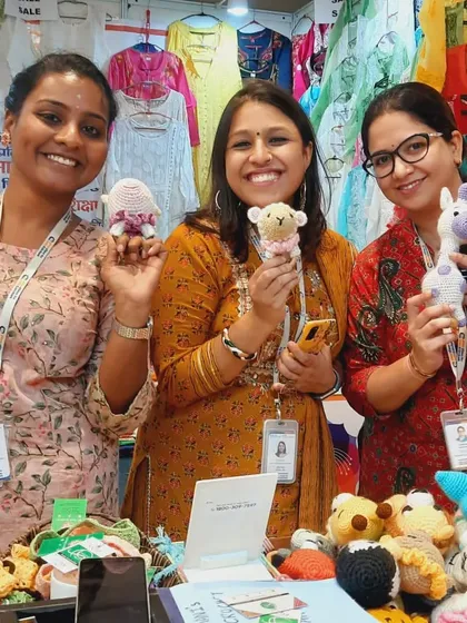 Happy visitors at our exhibition stall, holding up their favorite amigurumi toys. These small, handcrafted treasures bring smiles to faces of all ages.