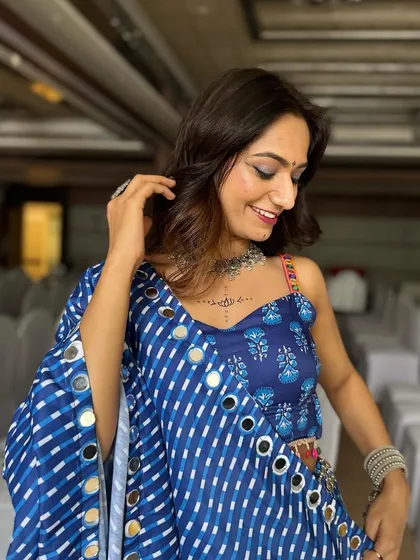 A happy, smiling client ready for Navratri. Her soft glam makeup with a hint of shimmer is the perfect complement to her traditional mirror-work attire.