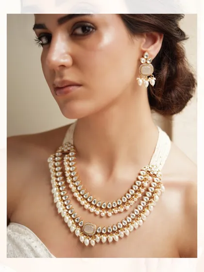 Three strands of pearls and polki come together in this elegant layered necklace, perfect for adding a touch of classic grace.