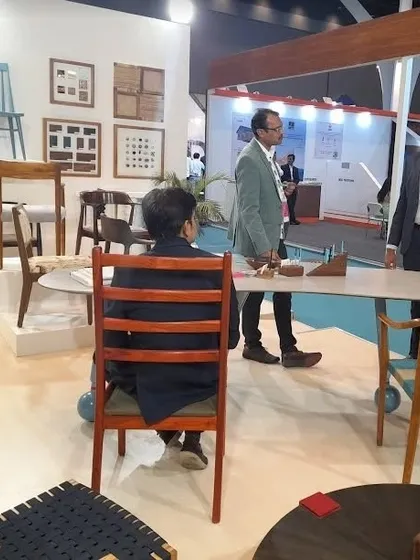 A visitor taking a moment to test the comfort and build of one of my custom dining chairs at the exhibition.