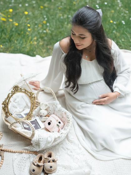 A beautifully styled flat lay of memories in the making. This shot includes sonogram pictures, baby shoes, and a camera, capturing the details of this special journey.