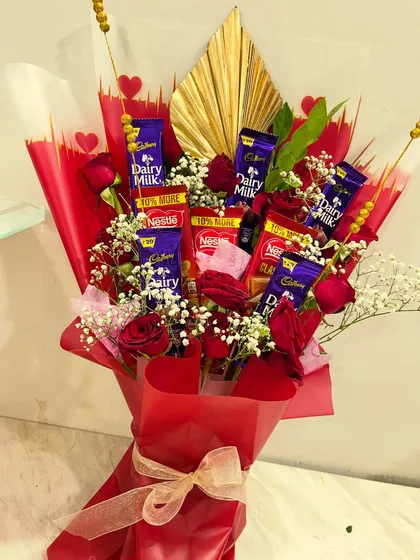 This bouquet is a chocolate lover's dream, featuring an assortment of Cadbury and Nestle bars mixed with real red roses. The gold fan detail adds a touch of elegance to this delicious arrangement.