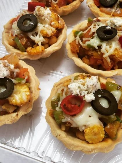 A closer look at our Tex-Mex Tarts, showing the delicious filling of corn, beans, and peppers, topped with melted cheese, feta, and a slice of black olive.