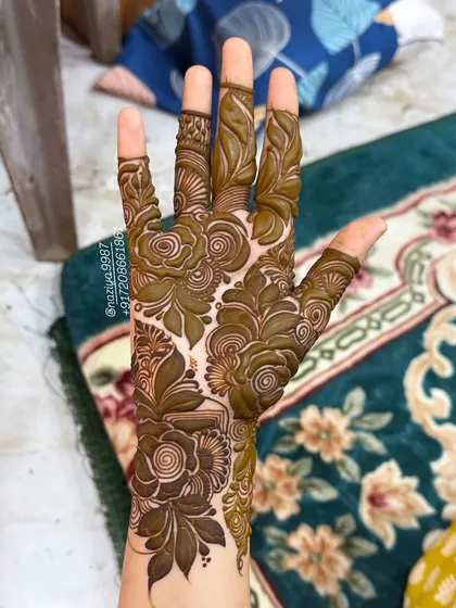 This design focuses the dense floral pattern on the back of the hand, leaving the fingers with simpler, complementary motifs.
