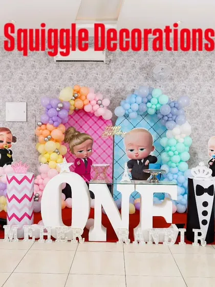 A Boss Baby themed first birthday party with multiple character cutouts and a large marquee 'ONE'. The pastel balloon colors create a soft and celebratory look.