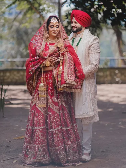 The groom helps his bride with her elaborate lehenga. It's these small acts of care and partnership that we love to capture on a wedding day.