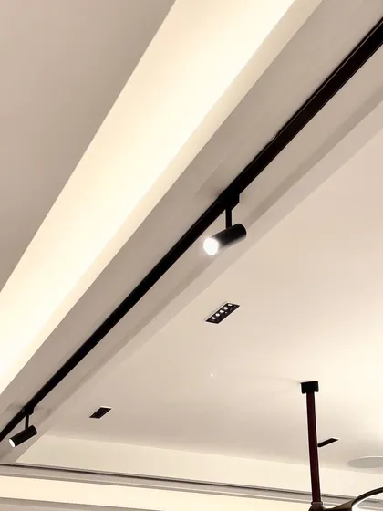 Here, a magnetic track system is used to create a clean, architectural line in the ceiling. The spotlights can be easily moved and repositioned, offering complete flexibility to highlight different areas as the needs of the space change over time.