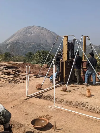 The process of creating rammed earth walls at Unnathi Farm, with the formwork set up against the backdrop of the Magadi hills.