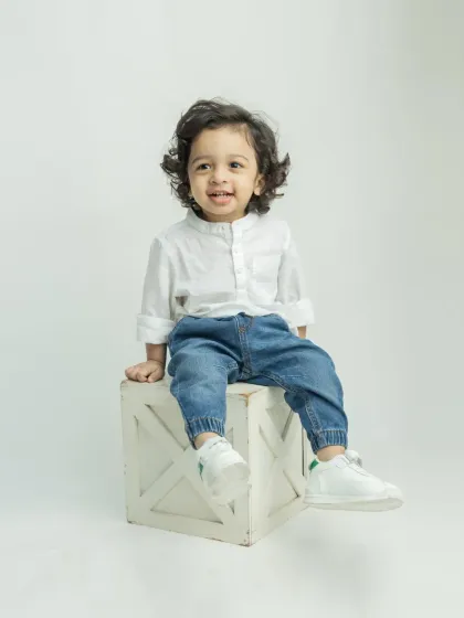 A handsome portrait of the little boy from the twin session, looking so cute in his white shirt and jeans.
