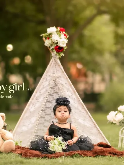 A dreamy bohemian-themed outdoor session featuring a little girl in a lace teepee, surrounded by a teddy bear and flowers. This setup is perfect for creating whimsical, storybook portraits.