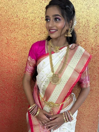 A beautiful, natural look for a bride in a white and pink saree. The makeup is soft and luminous, perfect for a daytime event.