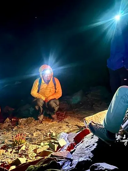 A night halt during the Yunam Peak expedition, with headlamps lighting up the darkness as the team prepares for the summit push.