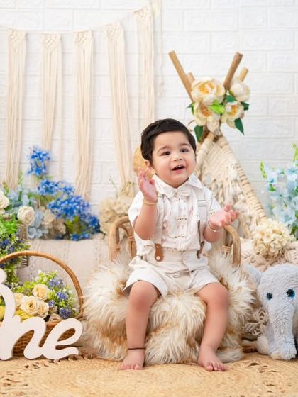 A full view of the blue and cream boho setup. The teepee, jute rug, and elephant plushie come together to create a whimsical and stylish scene for a first birthday.