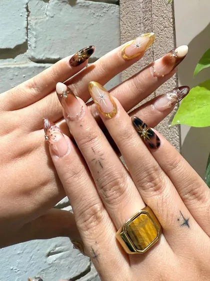 This angle shows off the client's own star tattoos, which we incorporated into the celestial theme of the nail art.