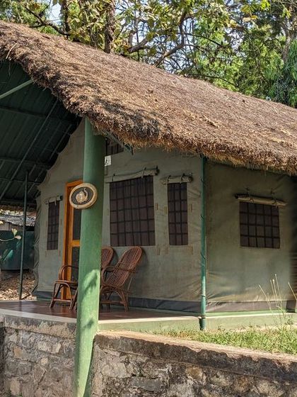 A thatched-roof tented cottage at Kali Adventure Camp, offering a rustic yet comfortable stay close to the river.