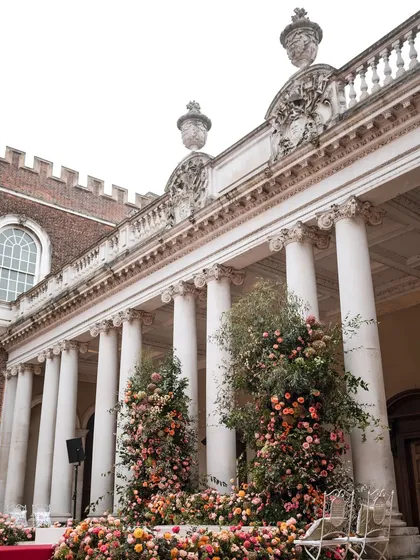 The grand colonnade of a historic royal palace in the UK, with the mandap nestled between the pillars. We specialize in integrating wedding structures seamlessly into architecturally significant venues.