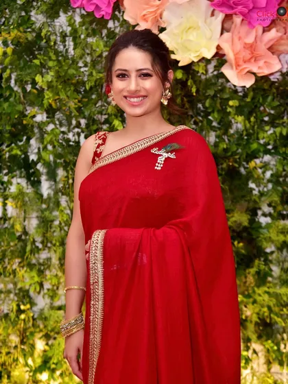 A candid portrait of a guest at a family celebration. Her bright smile and radiant red saree add to the vibrant and festive atmosphere of the event, which we love to capture.