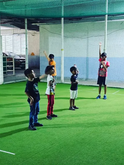 Young players doing arm stretches during their warm-up. We teach them the importance of preparing their entire body for practice.