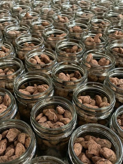 Preparing a bulk order of our popular Choco Almond Jars. These are a perfect gift for any occasion, from corporate events to wedding favors.