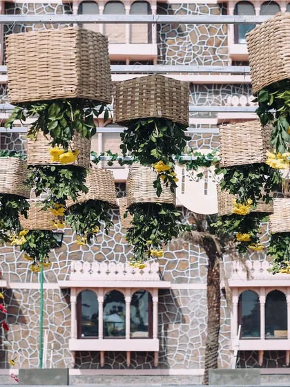 For a unique 'lemon-themed' Mehendi or Haldi in Jaipur, I designed this installation of hanging baskets and floral strings against the palace's beautiful stone architecture.