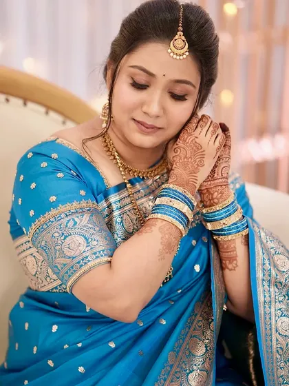A beautiful candid moment showing Sushmita adjusting her earring. The makeup looks flawless up close, highlighting the detailed eye work.