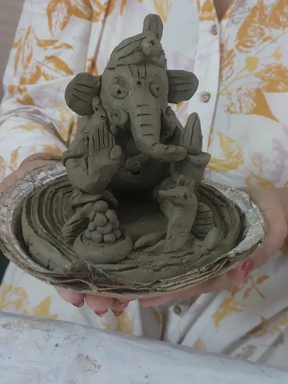 An intricately detailed Ganesha idol, sculpted from clay and placed in a shell. This piece showcases the beautiful results that can be achieved with natural materials and patient hands.