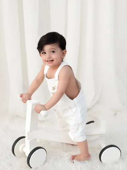 A happy toddler learning to walk with a stylish wooden walker. My studio is a safe and comfortable space to capture these exciting firsts.
