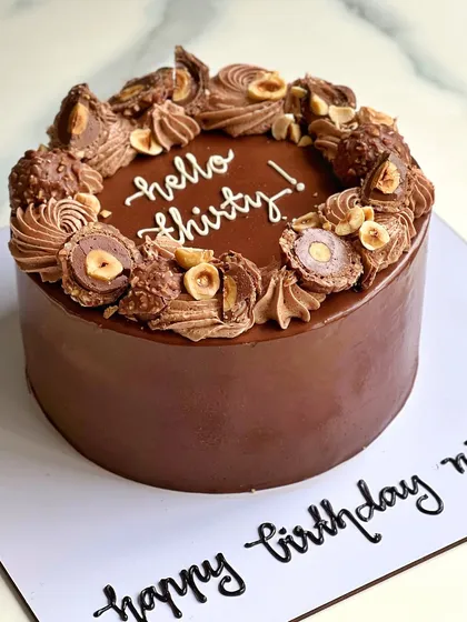 A "Hello Thirty" birthday cake in our popular Nutella Ferrero Rocher flavor. It's topped with chopped Ferrero Rocher and toasted hazelnuts for extra crunch and flavor.