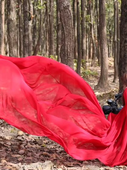 Another take on the edgy forest shoot, this time with the couple on the motorcycle. The red infinity trail gown adds a pop of high fashion to the rustic scene.