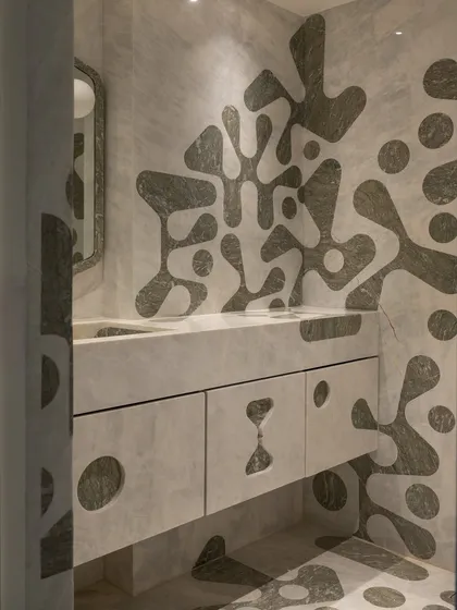 We pushed the boundaries of material and geometry in this powder bathroom. The walls, integrated vanity, and even the sculptural sink basin feature a bold, amoeba-like pattern inlaid in contrasting marble. This required immense precision from our artisans to carry the inlay seamlessly from horizontal to vertical surfaces.