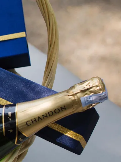 A close-up of a Chandon bottle paired with our signature blue velvet box. This pairing is available for our bespoke celebration hampers, adding a touch of sparkle to your gift.