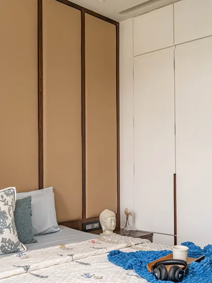 The kids' bedroom was designed with functionality at its heart. A full-wall leatherette headboard adds a cozy vibe, while sleek white cupboards provide ample storage to keep the room tidy and stylish.