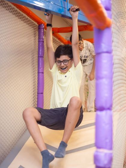The thrill of the ride! This boy enjoys a fun slide down from our padded climbing structure, landing safely every time.