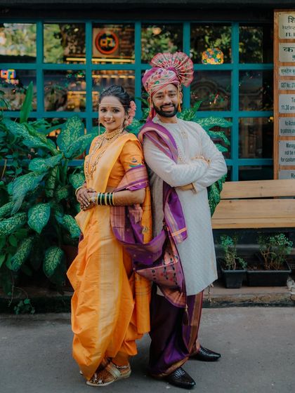 A fun and confident back-to-back pose from Rahul and Jagruti, perfectly displaying their stunning Maharashtrian wedding attire from head to toe.