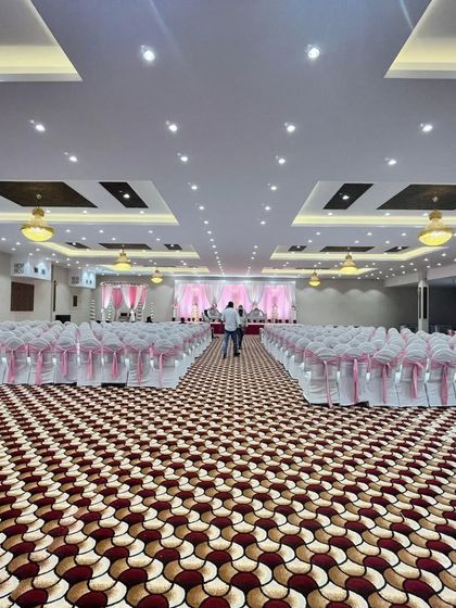 A straight-on view down the aisle at Royal Garden banquet. The symmetrical seating arrangement and vast space create a grand atmosphere for any wedding.