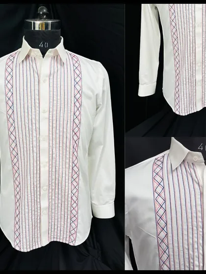A detailed look at the 'Fuchsia' shirt, featuring intricate pintucks and geometric embroidery in pink and blue thread. It's a vibrant and stylish choice.