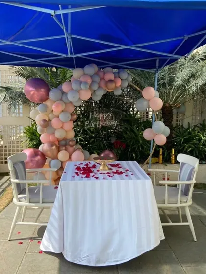 I love creating romantic surprises. For this special birthday, I arranged an intimate outdoor dinner setup under a canopy, complete with a beautiful balloon arch and a custom cake table.