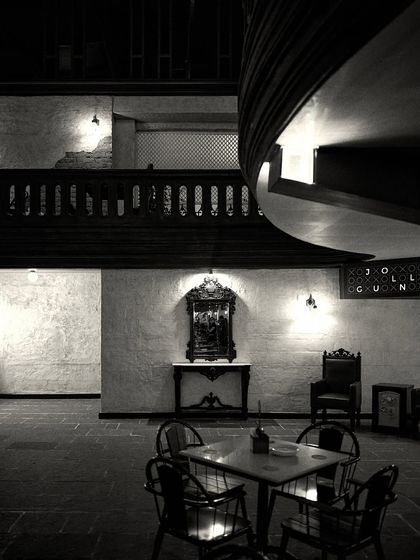 A quiet, dimly lit seating area, featuring a small table and an elegant mirror and console against the far wall. This shows the creation of intimate zones.