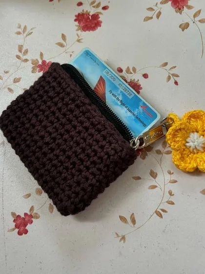 This minimalist crochet card wallet is perfect for when you only need to carry a few cards. It's small, lightweight, and features a secure zipper closure.
