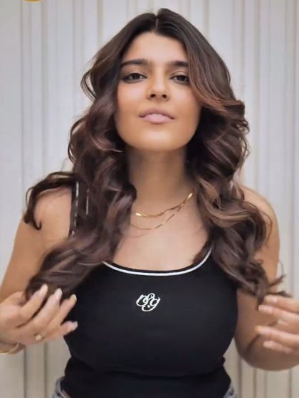 A client enjoying her new hair color and style. The soft brown tones and gentle waves create a fresh, modern, and confident look.