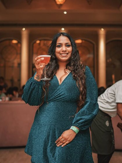 A guest smiles, cocktail in hand, embodying the elegant and celebratory spirit of an evening at Roxie.