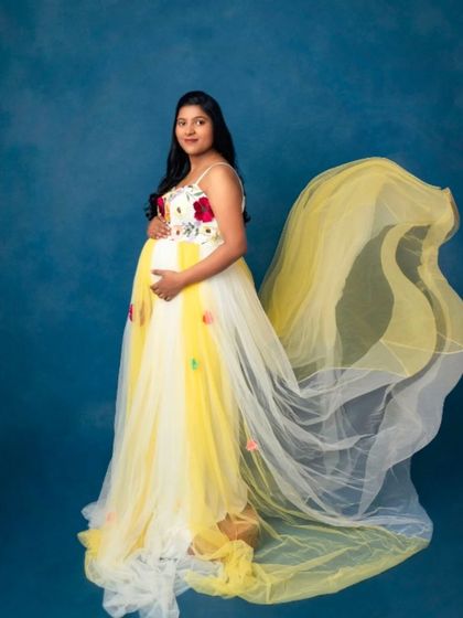 The sheer yellow train of this floral gown creates a beautiful flowing effect, perfect for capturing movement and grace.