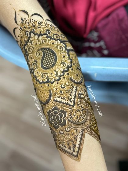 A close-up of the upper part of Musfira's design, featuring a large paisley motif with checkerboard filling.