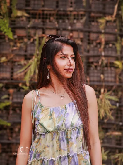 A thoughtful profile shot against a wall of greenery. The natural textures and soft light create a calm and organic feel.