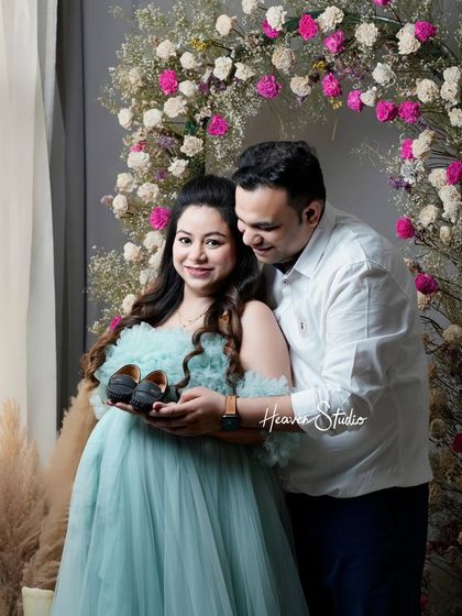Holding onto the promise of the future. This couple's portrait uses the simple prop of baby shoes to tell a powerful story of love and anticipation in a beautifully styled studio setting.