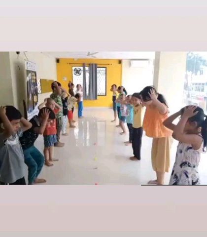 Children participating in a synchronized Brain Gym exercise. These simple, guided movements are designed to improve cognitive function, reduce stress, and enhance coordination between the left and right sides of the brain.