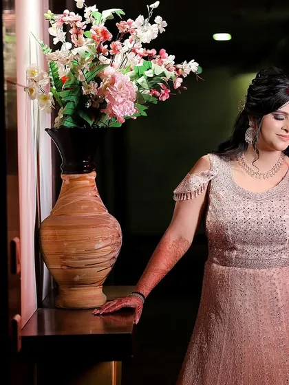 An elegant portrait of the bride in her beautiful gown, standing next to a vase of flowers. A timeless and classic shot.