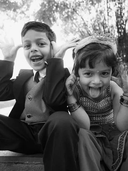 The kids are always the life of the party. This black and white photo of two children making funny faces for the camera is a perfect example of the genuine, fun moments we love to capture.