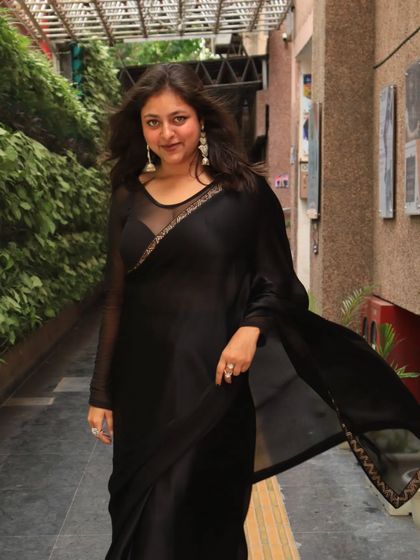 A front-facing shot of my black saree look. The sheer sleeves and delicate embroidery add a touch of modern elegance.