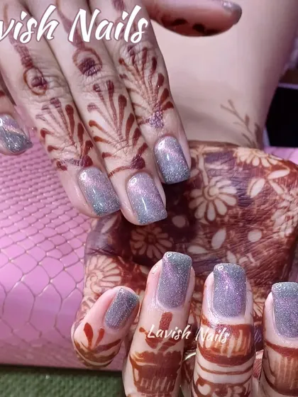 Subtle yet sparkling holographic glitter nails that catch the light beautifully, shown on a hand adorned with mehendi.